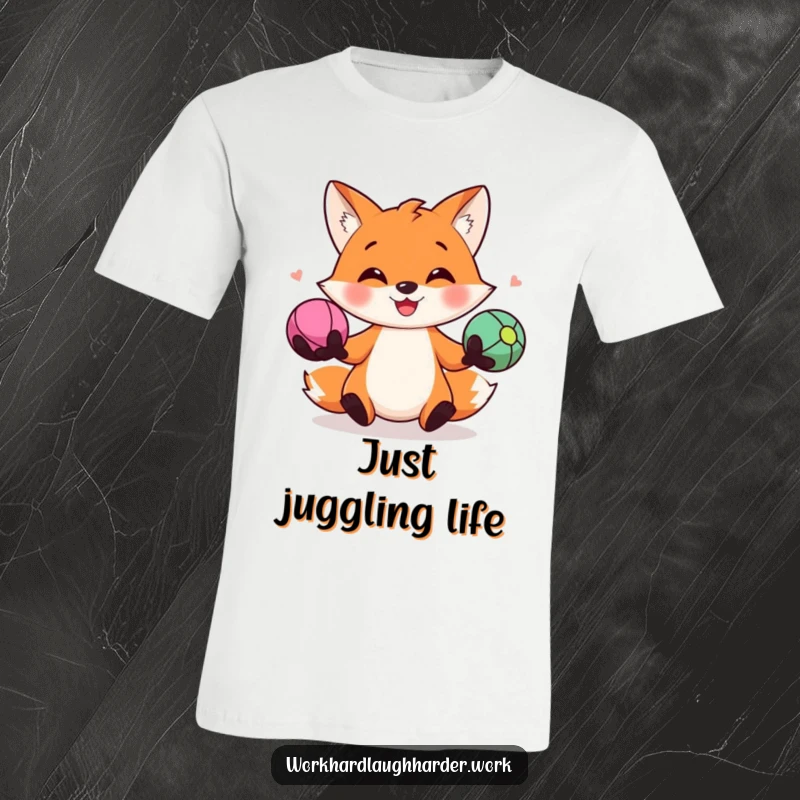 Funny t-shirt depicting a smiling fox skillfully juggling three vibrant stress balls, symbolizing cheerful multitasking and stress management.